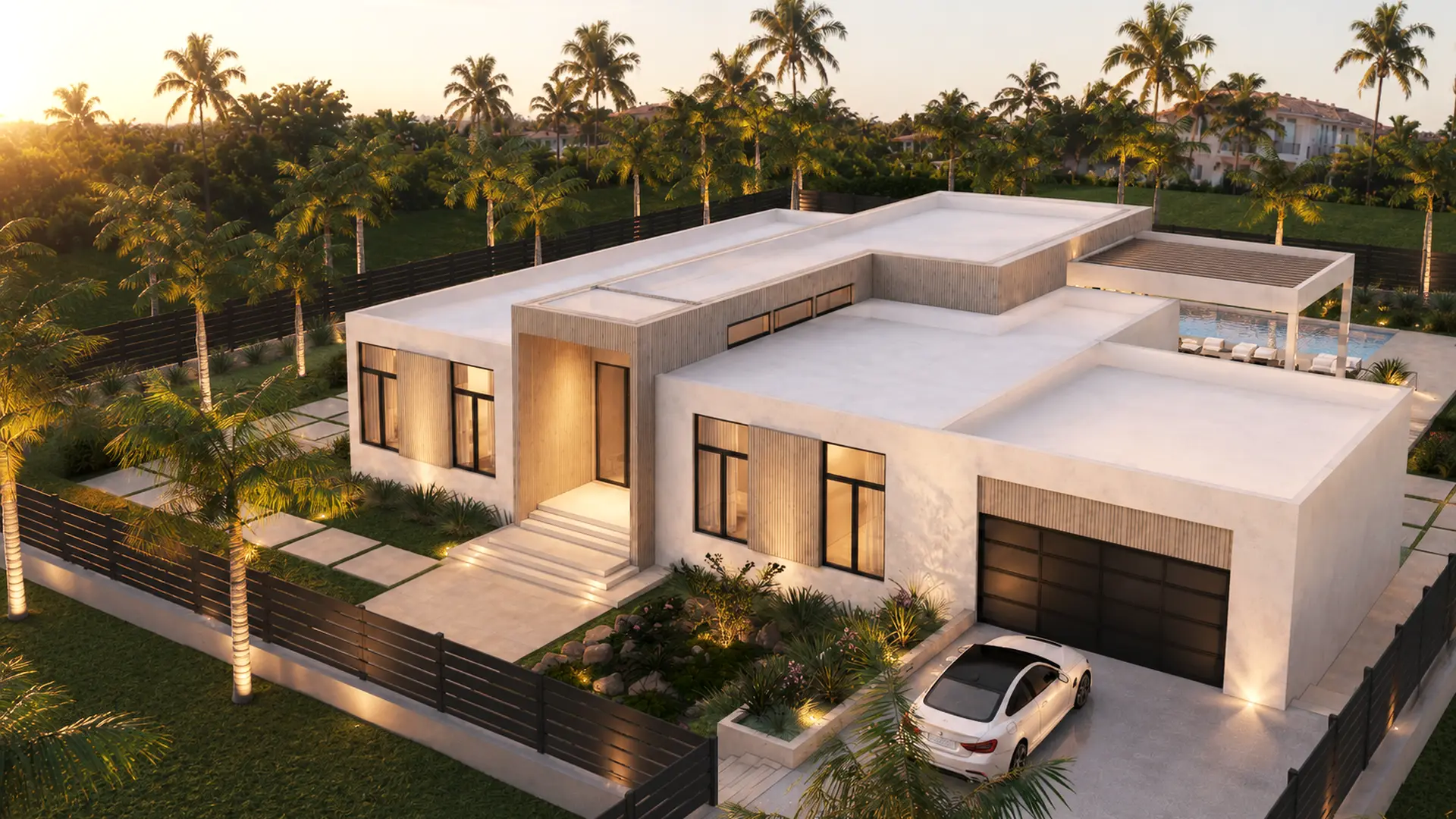 Aerial view of the villa from the front at sunset: entry steps, garage with a car, fenced lawn and palms all around